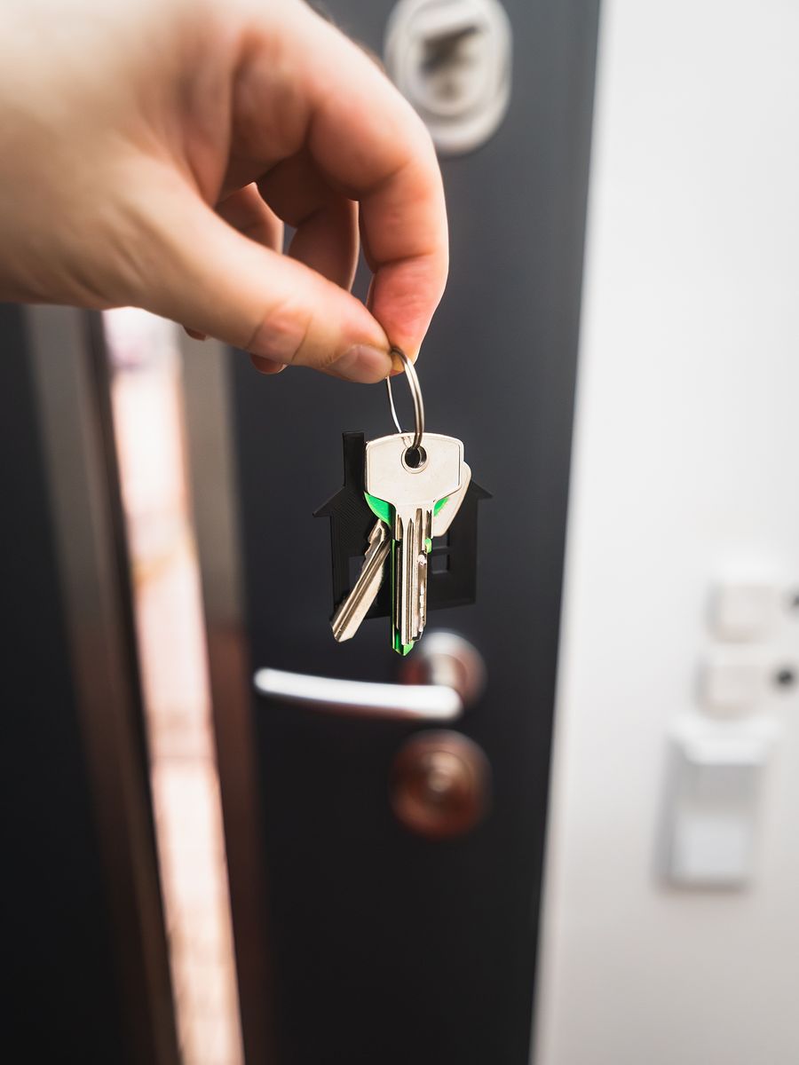 House keys held outside a front door